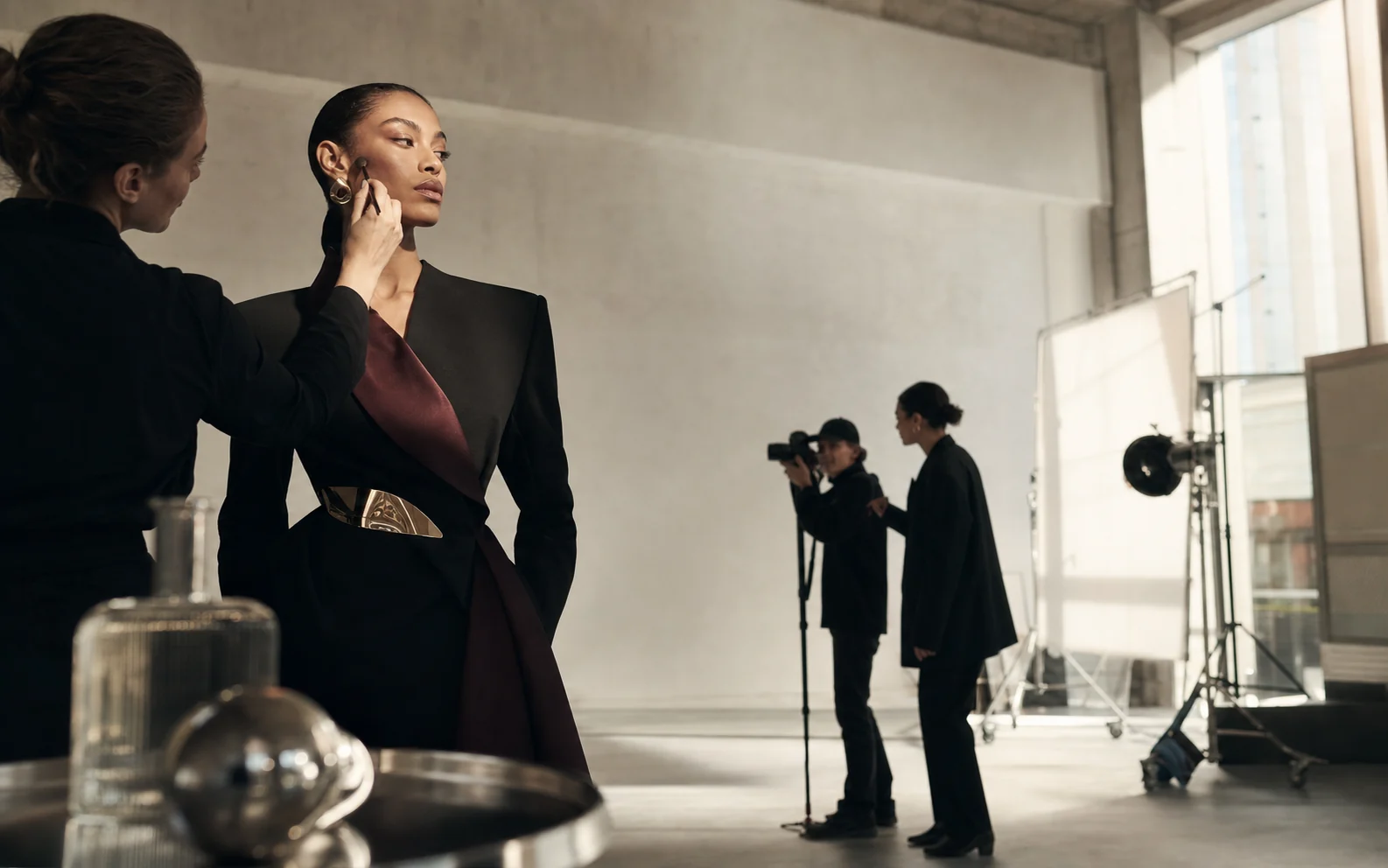 Fashion campaign in production with a model, makeup artist, photographer and studio team